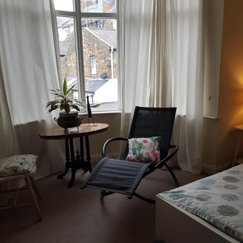 a room with a chair and a table and a window at Sea-view Panorama in Margate