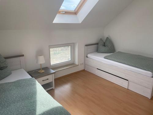 a small bedroom with two beds and a window at Gemütliche Ferienwohnung mit Kamin in Stadtilm