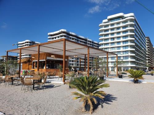 un pabellón con mesas y sillas frente a un edificio en Sea On Exclusive Studios, en Mamaia