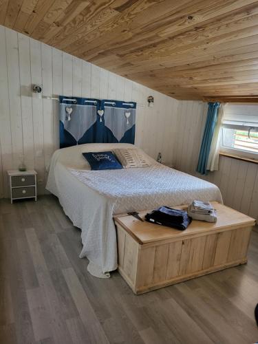 1 dormitorio con 1 cama y suelo de madera en Chambre d'hôtes le chat botté en Espédaillac
