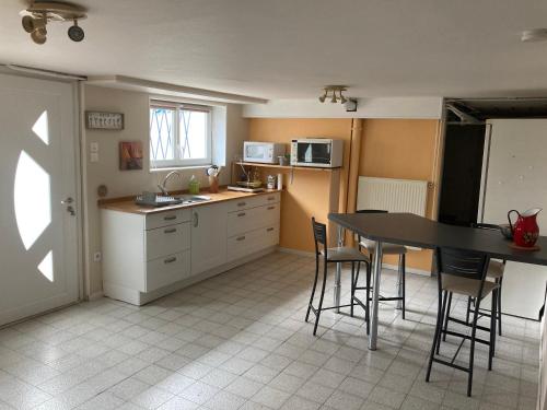 une cuisine avec une table et des chaises dans une cuisine dans l'établissement Appartement en rez-de-chaussée de maison, à Montanay