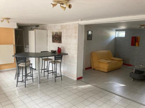 une cuisine avec une table, des chaises et un canapé dans l'établissement Appartement en rez-de-chaussée de maison, à Montanay