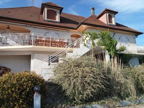 a house with a balcony on the side of it at Vaste villa en position dominante superbe vue lacs in Hautecour