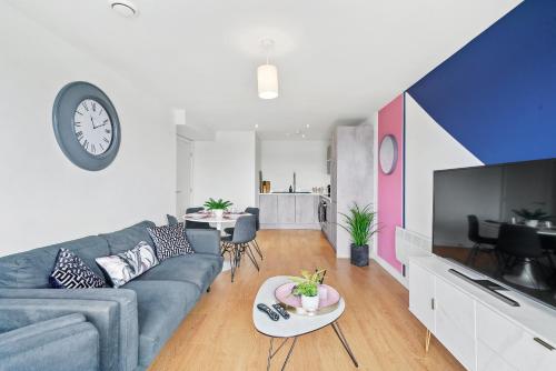 a living room with a couch and a clock on the wall at Stunning 2 Bedroom Apartment in Leeds