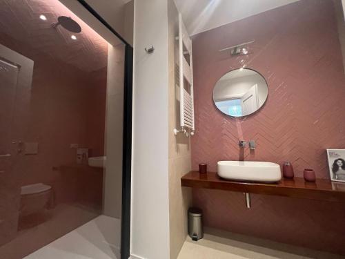 La salle de bains est pourvue d'un lavabo et d'un miroir. dans l'établissement AT HOME NAVONA, à Rome