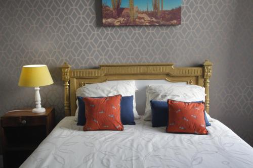 a bed with red and blue pillows in a bedroom at Nice apartment 10 minutes from Paris in Meudon