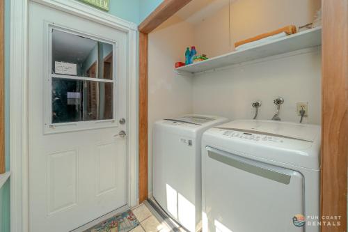 a laundry room with a washing machine and a sink at Flagler Avenue adjacent Dog Friendly Home with Garage! Stroll to the Beach! in Chicken Island