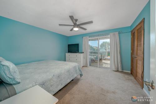 a bedroom with a bed and a ceiling fan at Flagler Avenue adjacent Dog Friendly Home with Garage! Stroll to the Beach! in Chicken Island