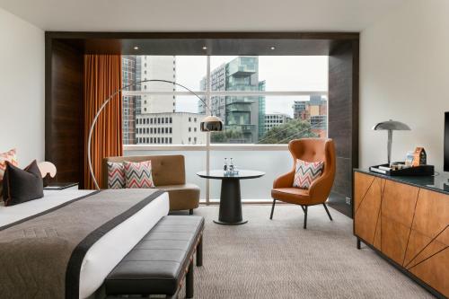 Habitación de hotel con cama, silla y ventana en The Lowry Hotel, en Mánchester