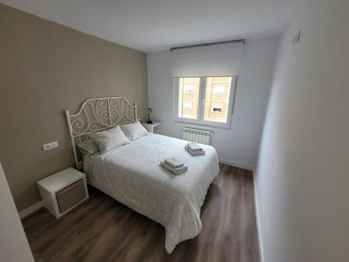 1 dormitorio con cama blanca y ventana en Apartamento con encanto en Avilés