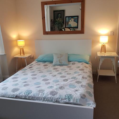 a bed in a bedroom with two lamps and a mirror at Sea-view Panorama in Margate