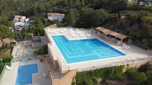 une vue aérienne d'une piscine dans une maison dans l'établissement Les ISSAMBRES appart 6 pers grande terrasse superbe vue mer et golfe de saint Tropez, piscine, aux Issambres