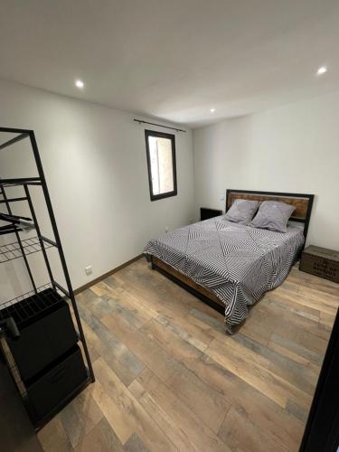 1 dormitorio con 1 cama y suelo de madera en BABILOC Industriel Appartement, en Riez