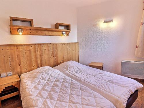 um quarto com uma cama e uma parede de madeira em Appartement La Tania, 2 pièces, 6 personnes - FR-1-182A-2 em Courchevel