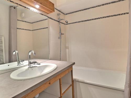 uma casa de banho com um lavatório e uma banheira em Appartement La Tania, 2 pièces, 6 personnes - FR-1-182A-2 em Courchevel