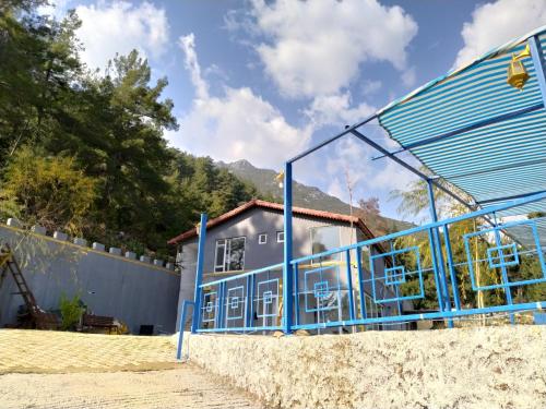 a house with a blue facade on a beach at TOKGÖZ HOTEL RESTAURANT in Ulupinar