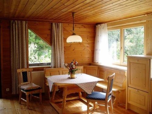 a dining room with a table and chairs and windows at Apartments Blaschegg im Zentrum in Altmünster