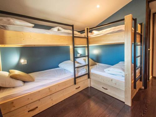 Ce dortoir aux murs bleus comprend 2 lits superposés. dans l'établissement Duplex 3 pièces avec balcon et casier à skis à Valmorel - FR-1-291-878, à Valmorel