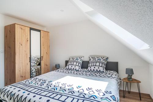 Schlafzimmer mit einem Bett mit blauen und weißen Kissen in der Unterkunft Gemütlich 6 in Wissembourg