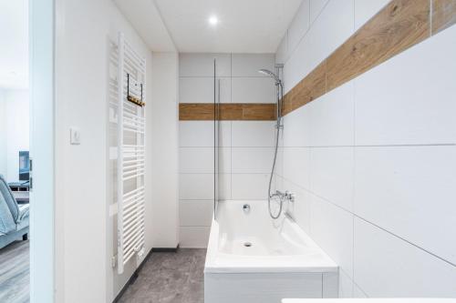 ein weißes Badezimmer mit einer Badewanne und einem Waschbecken in der Unterkunft Gemütlich 6 in Wissembourg