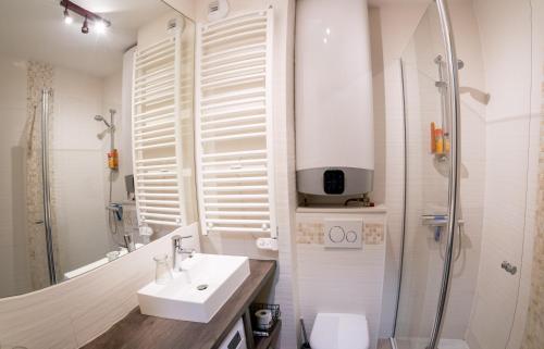 biała łazienka z umywalką i prysznicem w obiekcie Cabana & La Parmelante - Proche Lac w Annecy