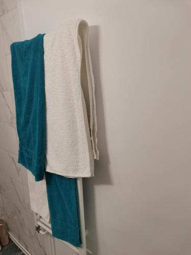 a pile of towels hanging on a rack in a bathroom at Bloom Box Apartments in Craiova