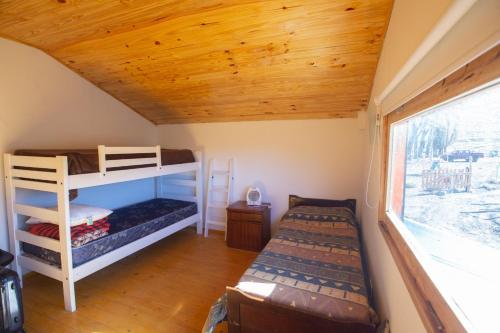 a bedroom with two bunk beds and a window at Los Molles - Helsinki Cabaña Nórdica de montaña in Los Molles