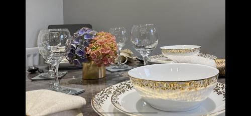a table with plates and bowls and glasses on it at Stylish Scottish House with garden and parking in Perth