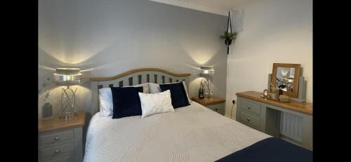 a bedroom with a bed with two lamps and a mirror at Stylish Scottish House with garden and parking in Perth