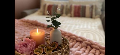 a candle and a vase on a table with a bed at Stylish Scottish House with garden and parking in Perth