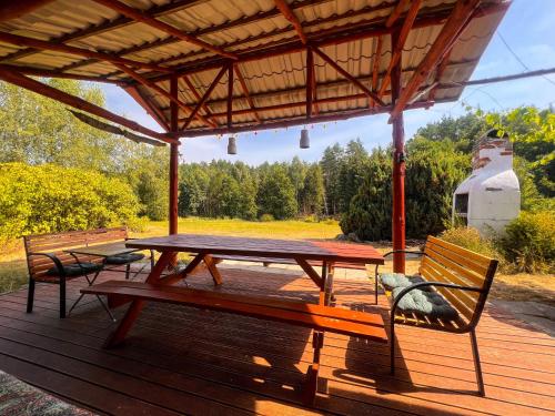 ein Picknicktisch und zwei Bänke auf einer Terrasse in der Unterkunft Agro - Dom Wsrod Lasow in Trzcianka