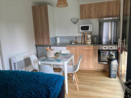une cuisine avec une table et des chaises dans une cuisine dans l'établissement MON PETIT BONHEUR, à Saint-Michel-Chef-Chef