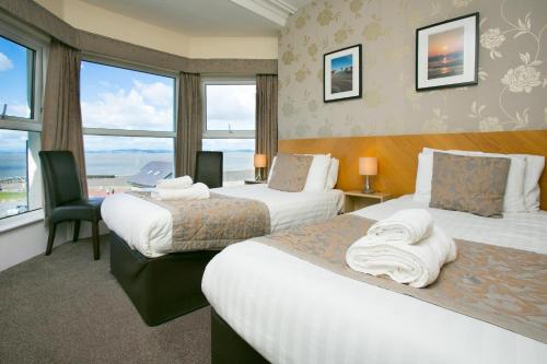 a hotel room with two beds and a window at The Auckland Hotel in Morecambe