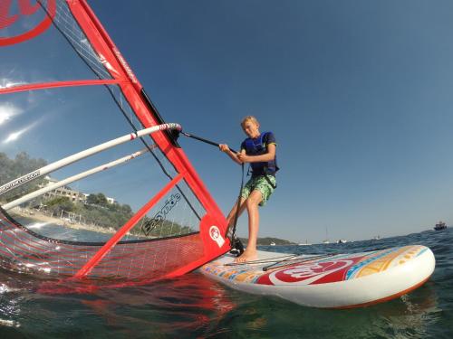a man is on a wind sail on the water at Eagles Villas - Small Luxury Hotels of The World in Ouranoupoli
