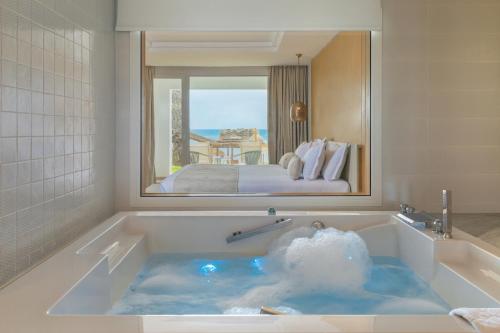 Royal Azur Thalassa في الحمامات: حوض في غرفة الفندق مع سرير