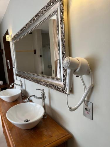 a bathroom with a sink and a mirror at Pousada Dona Bendita in Monte Verde