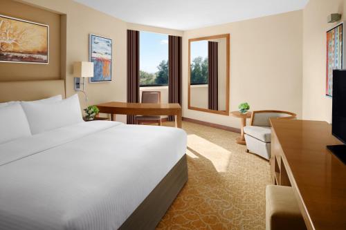 a hotel room with a white bed and a desk at InterContinental Al Jubail Resort in Al Jubail