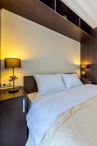a bedroom with a large white bed and a lamp at Однокімнатні апартаменти на Майдані, дистанційне заселення 24х7 in Kyiv