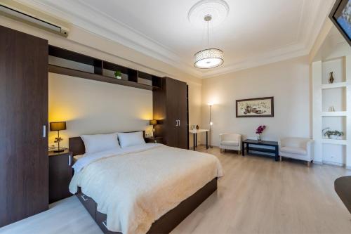 a bedroom with a large bed and a living room at Однокімнатні апартаменти на Майдані, дистанційне заселення 24х7 in Kyiv