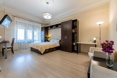 a bedroom with a bed and a desk and a couch at Однокімнатні апартаменти на Майдані, дистанційне заселення 24х7 in Kyiv
