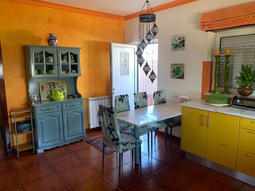 a kitchen with a table and yellow cabinets at Villa Porto de Mós near Fatima in Porto de Mós