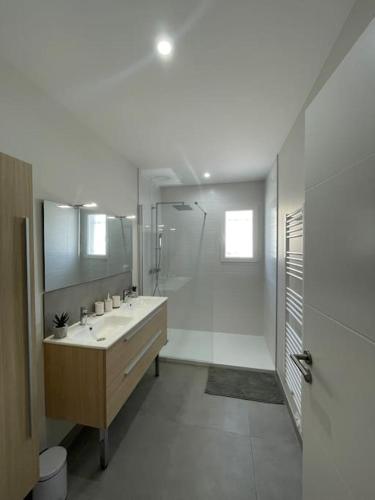 une salle de bain blanche avec un lavabo et une douche dans l'établissement Magnifique villa avec piscine extérieure, à Alleins