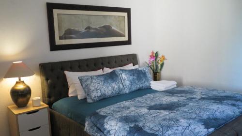a bedroom with a bed with a blue comforter at Galaxy Sleep And Go Rooms Goodwood in Cape Town
