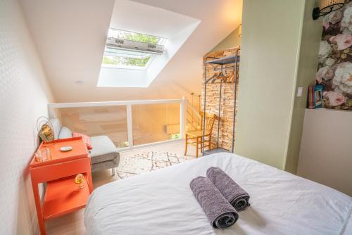 sypialnia z łóżkiem z dwoma fioletowymi ręcznikami w obiekcie Cabana & La Parmelante - Proche Lac w Annecy