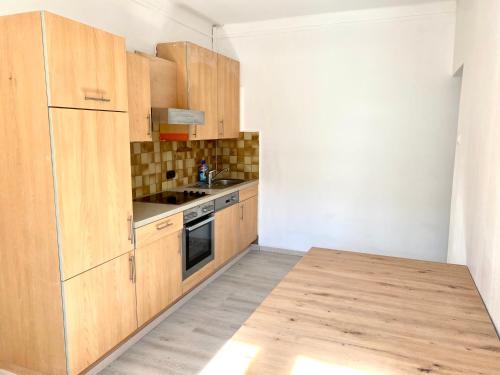 eine Küche mit Holzschränken und einem Holztisch in der Unterkunft Nice rooms in Beggen house - In Luxembourg city in Luxemburg (Stadt)