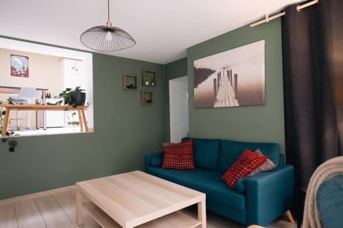 a living room with a blue couch and a table at La petite Citadelle - l'appartement in Namur