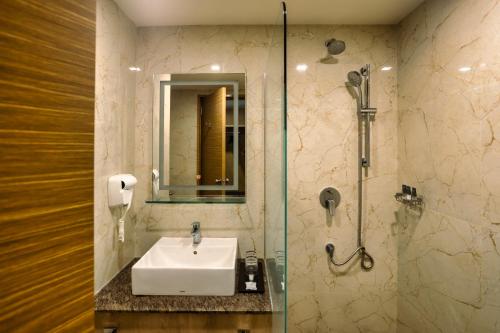 a bathroom with a sink and a shower at Amika Hotel,Madurai - Near Airport in Madurai