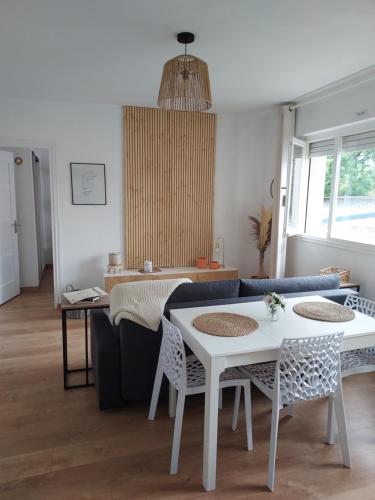 un salon avec un canapé, une table et des chaises dans l'établissement Au Nid d'or : Appartement Tout confort Hyper Centre Béthune, à Béthune