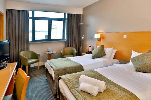 a hotel room with two beds and a television at Best Western Plus Nottingham City Centre in Nottingham