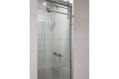 een douche met een glazen deur in de badkamer bij Studio Flat Suite Completo 519 in Cotia